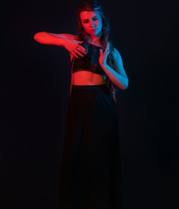 Woman in a graceful and harmonious yoga pose against a dark background.
